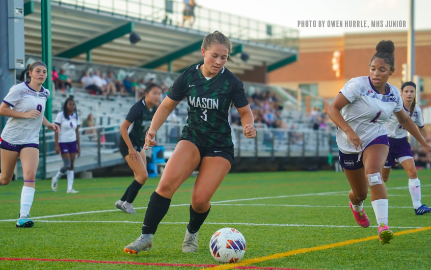 Mason girl preparing to kick ball as opponents try to steal